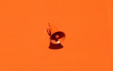 Orange megafon mot orange bakgrund